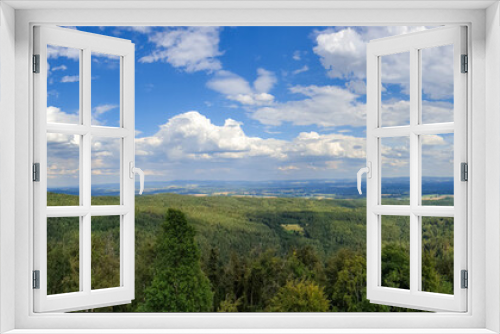 Fototapeta Naklejka Na Ścianę Okno 3D - Panoramic view of a green landscape under a cloudy blue sky on a sunny day