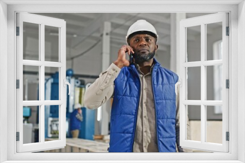 Portrait of a busy middle-aged African-American male with beard talking on the modern new smartphone. Man gesticulating and pointing out to one direction. Boss concept.