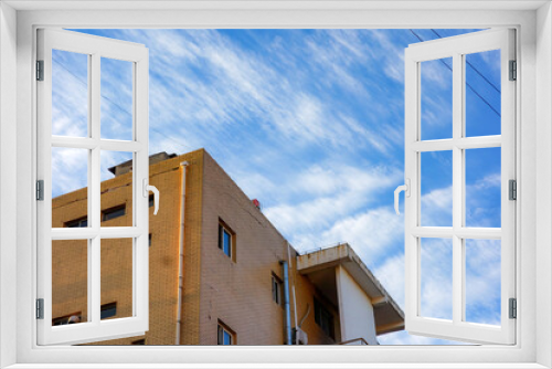 Fototapeta Naklejka Na Ścianę Okno 3D - The partial shape of buildings under the background of blue sky and white clouds