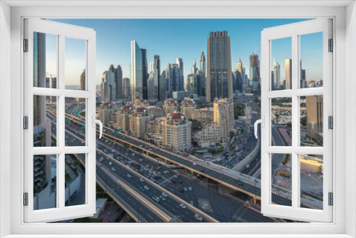 Fototapeta Naklejka Na Ścianę Okno 3D - Skyline view of the buildings of Sheikh Zayed Road and DIFC day to night timelapse in Dubai, UAE.