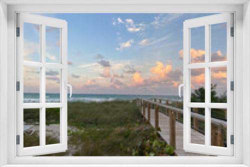 Fototapeta Naklejka Na Ścianę Okno 3D - Boardwalk into Florida beach at sunset with cloudy sky