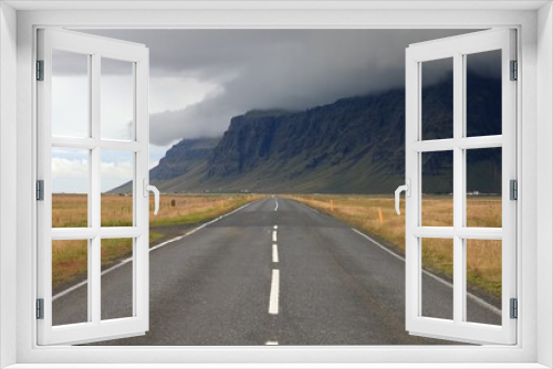 Fototapeta Naklejka Na Ścianę Okno 3D - Beautiful view of a road with dry fields and mountains under the cloudy sky