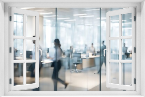  Blurred office with people working behind glass wall 