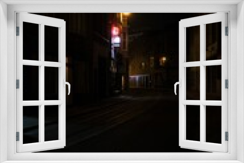 Fototapeta Naklejka Na Ścianę Okno 3D - Narrow street surrounded by buildings in night