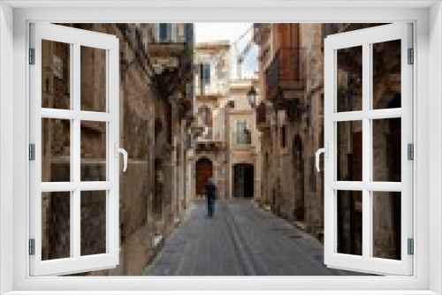 Fototapeta Naklejka Na Ścianę Okno 3D - Vertical shot of a historic alley with old buildings in Syracuse, Sicily, Italy