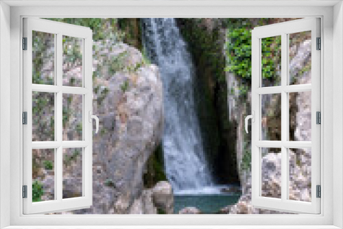 Fototapeta Naklejka Na Ścianę Okno 3D - Secluded waterfall cascades into a serene rock pool, a hidden gem tucked away in a lush Spain mountain ravine.