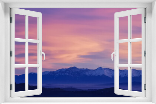 Fototapeta Naklejka Na Ścianę Okno 3D - Tramonto luminoso viola arancio e rosa sopra le montagne innevate