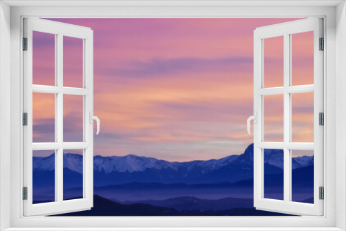 Fototapeta Naklejka Na Ścianę Okno 3D - Tramonto luminoso viola arancio e rosa sopra le montagne innevate