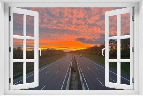 Fototapeta Naklejka Na Ścianę Okno 3D - German highway A2 from above, bright red sunset sky panorama with fleece colorful clouds. Near Langenhagen Godshorn, district Hanover, Lower Saxony, Northern Germany.