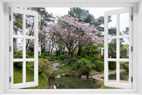 Fototapeta Naklejka Na Ścianę Okno 3D - A beautiful garden with a pond and a tree with pink flowers