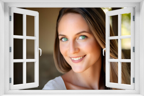 The attractive young woman with colorful eyes, smiling towards the camera in close-up