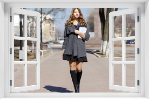 Schoolgirl walking on spring sunny street