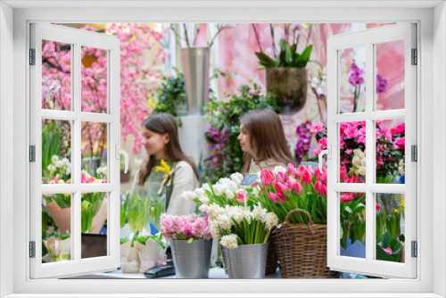 Fototapeta Naklejka Na Ścianę Okno 3D - Baskets with a variety of spring flowers - tulips, phlox, begonias. Showcase of a cheerful flower shop.