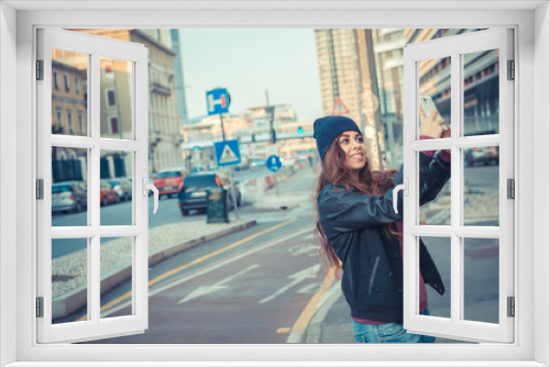 Beautiful girl taking a selfie in the city streets