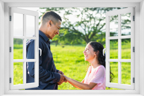 little brunette latina girl looking proudly at her father as they are both smiling with laughter