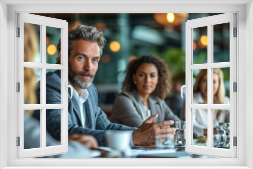 A group of people are sitting around a table having a meeting.