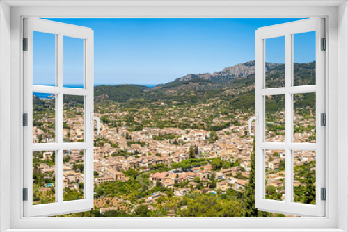 Panorama of Sóller, with Port de Sóller and the azure Mediterranean Sea, nestled in the lush Valley of Oranges amidst Serra de Tramuntana mountains, ideal for seekers of natural beauty and serenity.