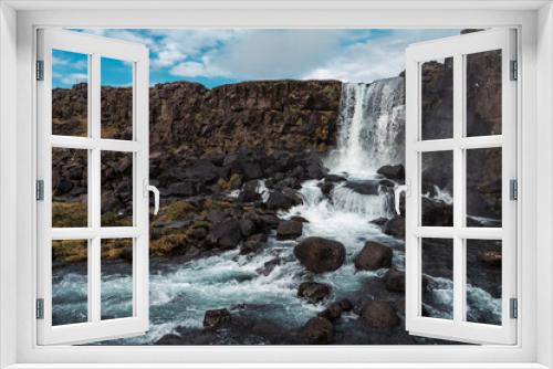 Fototapeta Naklejka Na Ścianę Okno 3D - Oxararfoss, spectacular Icelandic waterfall. Þingvellir National Park. Cold water falls on large black boulders of volcanic origin.