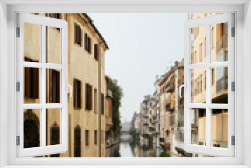 Fototapeta Naklejka Na Ścianę Okno 3D - The city canal San Massimo in Padua. Beautiful urban view of residential buildings with balconies in the center of the old city Padova, Veneto. Rivers Brenta and Bacchiglione, Italy