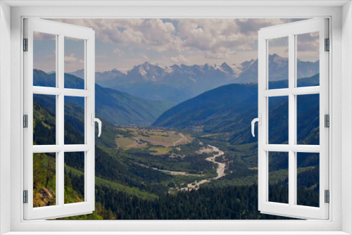 Fototapeta Naklejka Na Ścianę Okno 3D - Breathtaking view of a verdant alpine valley and towering mountains under a clear sky, ideal for Earth Day and environmental conservation themes