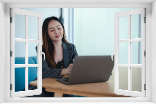 Asian female office worker or businesswoman is using a laptop to work in the office.