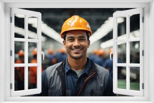 Male factory worker wearing hat and safety suit on production line background