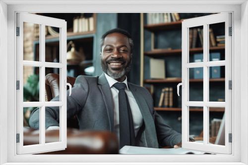 Confident African American businessman wearing a gray business suit in his office against the backdrop of bookshelves and smiling softly, showing professionalism and experience.