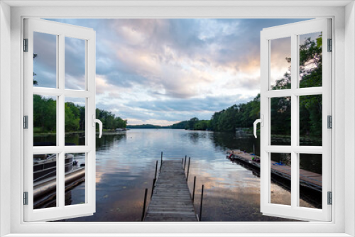 Fototapeta Naklejka Na Ścianę Okno 3D - Looking out onto a Wisconsin northwoods lake as the last rays of sunlight begin to fade.  Many pontoon boats have returned from fishing for the evening.