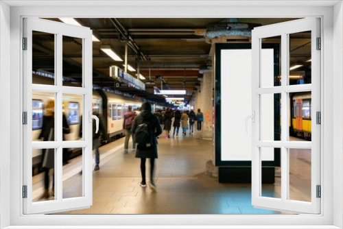 In the heart of the train station, a lightbox vertical billboard with a blank digital screen stands out. This mockup, featuring a white poster, is ideal for displaying public information or ads to 