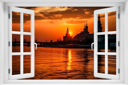 Stunning sunset over a tranquil river with silhouette of a historic temple and bridge reflecting vibrant orange hues in the sky and water creating a serene and picturesque evening scene.