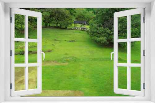 Fototapeta Naklejka Na Ścianę Okno 3D - Aerial view of a green park with tall trees around it