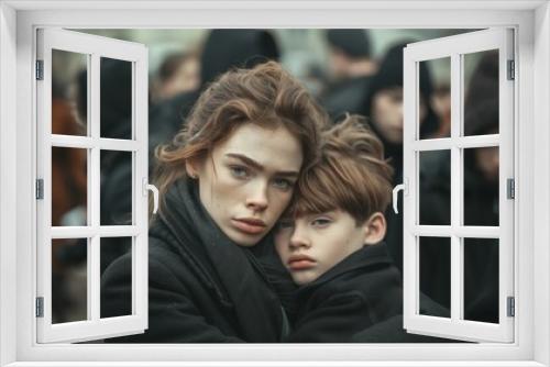 A mother with sad child in a cemetery, a brace for the loss of the parents' father, a funeral