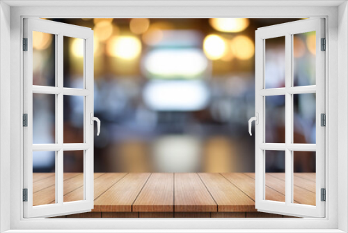 Empty wooden table top with lights bokeh on blur restaurant background.