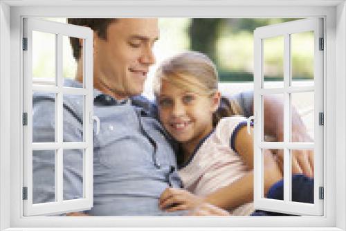 Father And Daughter Sitting On Sofa At Home