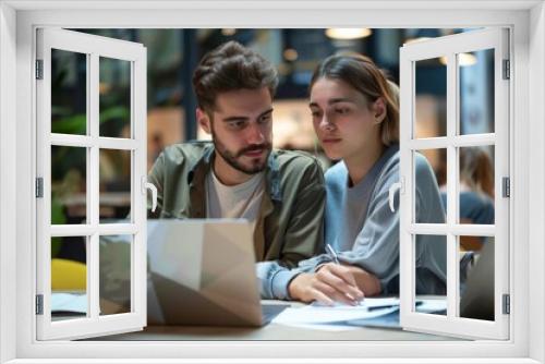 A happy young business woman and male colleagues are working together on laptops in the office, looking at documents. Concept photo, about the passion of a human resources team