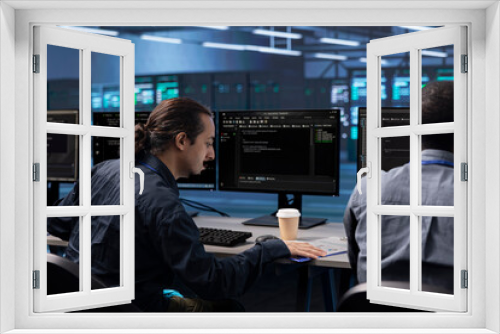 Coworkers in data center workspace running system diagnostic tests to do repairments. IT experts at PC desk in server hub deploying error checking utilities to fix network issues