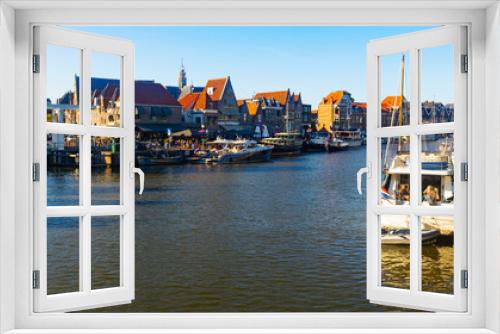 Fototapeta Naklejka Na Ścianę Okno 3D - View of Hoorn city port located on lake Markermeer with pleasure boats moored along waterfront and typical townhouses with terracotta tiled roofs on sunny summer day, Netherlands .