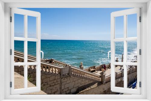 Fototapeta Naklejka Na Ścianę Okno 3D - Sunny seaside promenade with decorative balustrade overlooking the turquoise ocean, ideal for vacation and summer travel themes Related concepts: travel, summer vacations