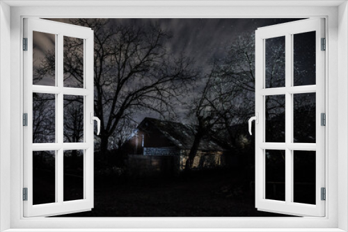 Fototapeta Naklejka Na Ścianę Okno 3D - Old house with a Ghost in the forest at misty night or Night scene with House under moon. Old mystic building in dead tree forest.