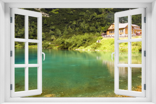 Fototapeta Naklejka Na Ścianę Okno 3D - Chalet  next to a  green mountain lake