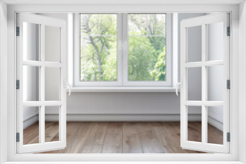 Window filling an empty apartment room with natural lighting. Residential interior design composition with copy space for an ad.