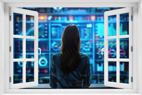 Businesswoman analyzing big data on large screen with charts, graphs, and neural statistics in monitoring room