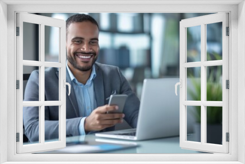 Smiling business professional using mobile phone at desk