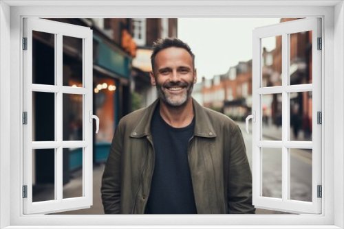 Portrait of handsome man in casual clothes smiling at camera while standing outdoors