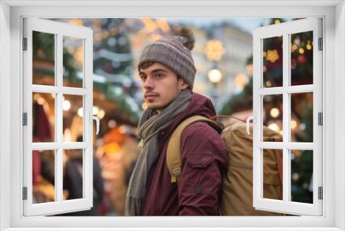 View of a young man holding a backpack while shopping in the holiday market.