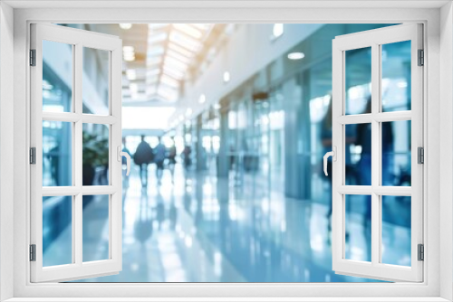 A blurred background of a wide passageway in a modern office building, with people walking and interacting