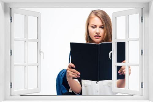 Girl with backpack reading book