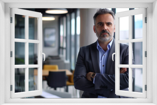 businessman standing in modern office looking at camera