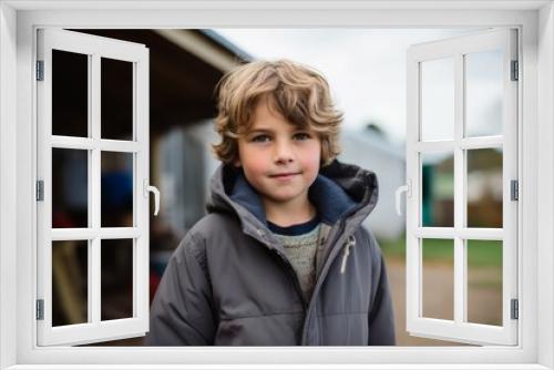 Portrait of a cute little boy standing outside in the countryside.