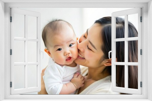 mother holding and kissing her baby smiling baby with love